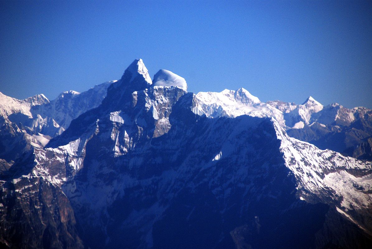 Kathmandu Mountain Flight 04-1 Gauri Shankar Wide View The twin summits of sacred Gauri Shankar and the step south face are clearly visible on the Kathmandu mountain flight. The higher northern summit (7134m) of Gauri Shankar is called Shankar, a manifestation of Shiva, and the lower southern summit (7010m) is called Gauri, a manifestation of Shiva's consort. Gauri Shankar has only been climbed a few times because of its extremely difficult steep faces and long, corniced ridges.